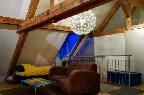 un salon avec une chaise et un lustre dans l'établissement Large duplex with terrace, à Strasbourg