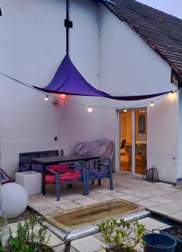 un patio avec une table de pique-nique et une tente violette dans l'établissement Large duplex with terrace, à Strasbourg