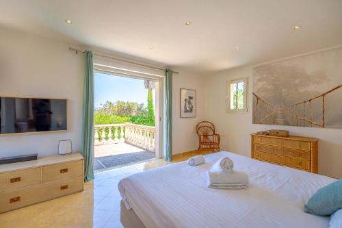une chambre avec un lit et une télévision et un balcon dans l'établissement Villa La Perle l Pool & Terrace l Shellter Rentals, à Saint-Tropez
