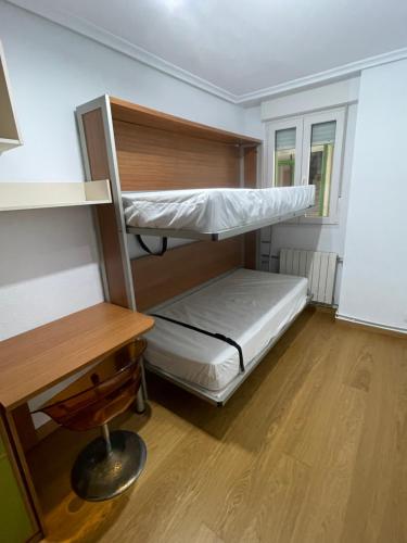 a room with two bunk beds and a desk at Apartamento con piscina y WIFI a 100 metros de la playa en Somo in Somo