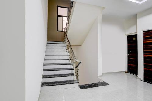 a staircase in a room with white walls at FabHotel Casa in Nagpur