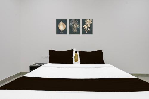 a bedroom with a white bed with black pillows at FabHotel Casa in Nagpur