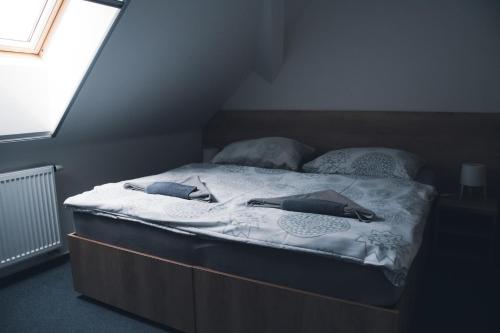 a bed with two pillows on it in a bedroom at Penzion Kometa - rodinný pobyt u Novomlýnských jezer s komfortem, restaurací a dětskou zónou in Pasohlávky