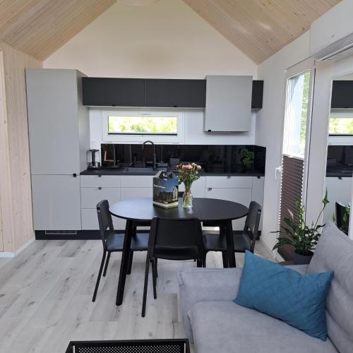 a kitchen and living room with a table and chairs at Domki Wilków z widokiem na Łysicę in Wilków