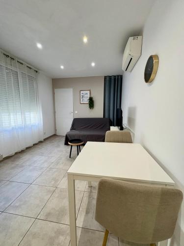 un salon avec une table et un canapé dans l'établissement Studio climatise #3 a 10 min des plages, à Perpignan