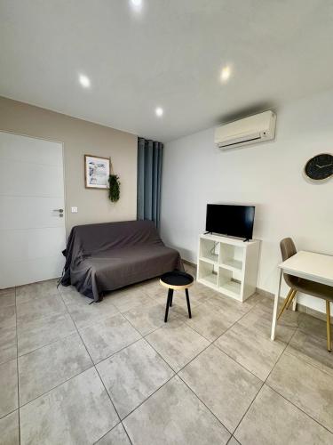 une chambre avec un lit, une télévision et un bureau dans l'établissement Studio climatise #3 a 10 min des plages, à Perpignan