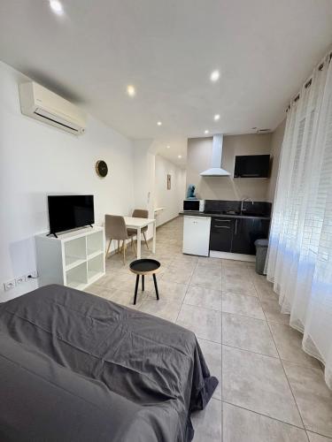 un salon avec un lit et une cuisine dans l'établissement Studio climatise #3 a 10 min des plages, à Perpignan