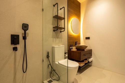 a bathroom with a shower with a toilet and a sink at Palermo Suites by Betterplace in Ubud