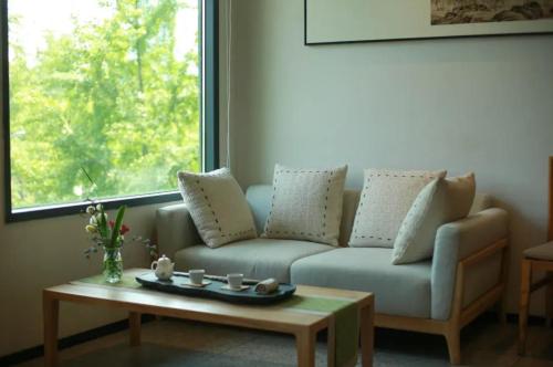 a living room with a couch and a coffee table at 隐栖堂酒店 成都太古里合江亭店 in Chengdu