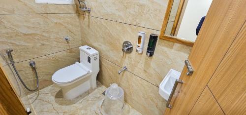 a bathroom with a toilet and a shower stall at Hotel Nova Venus in Rajkot