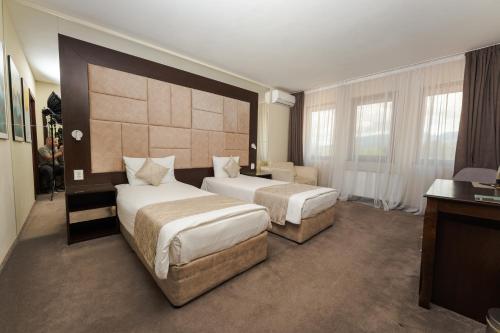 a hotel room with two beds and a desk at Family Hotel The View & SPA in Tsigov Chark
