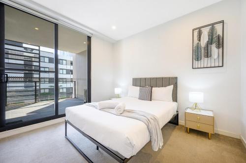 a bedroom with a large bed and a large window at Penrith 2Br apt close toTrain station Shopping in Penrith