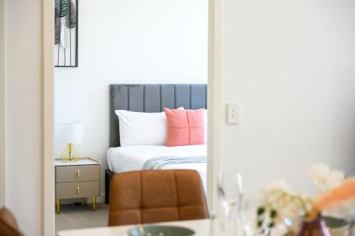 a mirror reflection of a bedroom with a bed with pink pillows at Penrith 2Br apt close toTrain station Shopping in Penrith