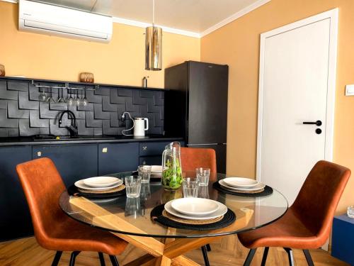 a kitchen with a table with chairs and a black counter at Biała mewa in Huta