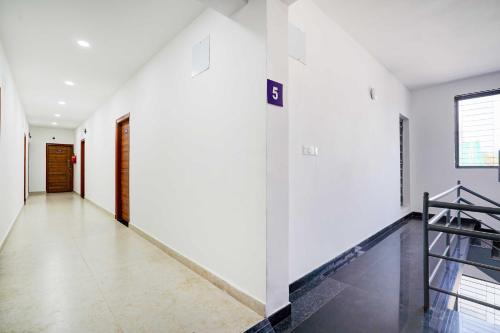 a hallway of a house with white walls and a staircase at Collection O Jeevan Bima Nagar HAL Road in Bengaluru
