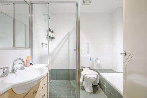 a bathroom with a shower and a toilet and a sink at Burwood 2Br Apt Near Chiantown Shopping Center in Sydney