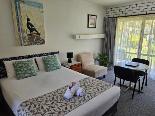 a bedroom with a bed with a stuffed animal on it at Barooga Country Inn Motel in Barooga