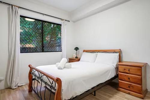 a bedroom with a bed with a teddy bear on it at Burwood 2Br Apt Near Chiantown Shopping Center in Sydney