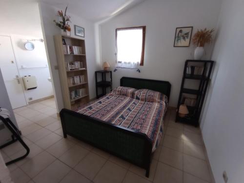 une chambre avec un lit et une étagère dans l'établissement Villa calme climatisée idéalement située Mer Port Centre, à Saint Cyprien Plage