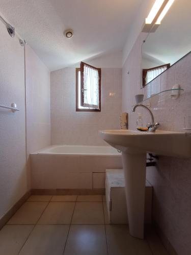 une salle de bain blanche avec un lavabo et une baignoire dans l'établissement Villa calme climatisée idéalement située Mer Port Centre, à Saint Cyprien Plage