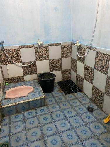 ein Badezimmer mit einer rosa Toilette auf einem gefliesten Boden in der Unterkunft Kabin Sahara in Pulau Tidung-kecil