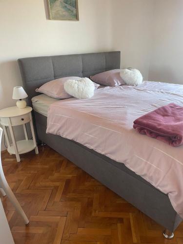 a bedroom with a bed with pink sheets and pillows at Apartment " So" in Senj