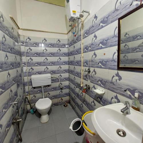 a bathroom with a toilet and a sink at Shilong DC Guest House with View and Good Facilities in Guwahati