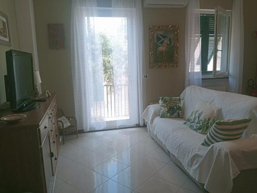 a living room with a couch and a television at CASA L'UNICORNO con giardino privato in Levanto