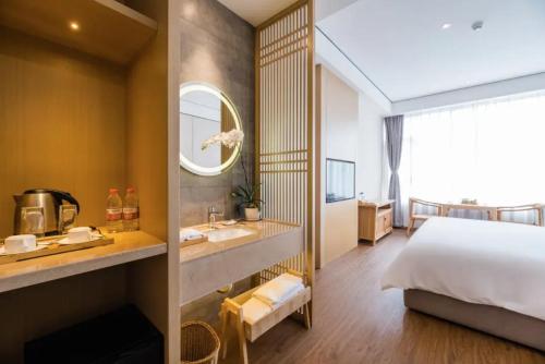 a bedroom with a bed and a sink and a mirror at 隐栖堂酒店 成都太古里合江亭店 in Chengdu
