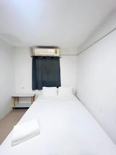 a bedroom with a white bed and a blue curtain at GO INN Siriraj BKK โกอินน์ ศิริราช in Bangkok Noi