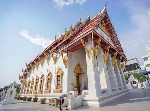 a building with a person sitting in front of it at GO INN Siriraj BKK โกอินน์ ศิริราช in Bangkok Noi