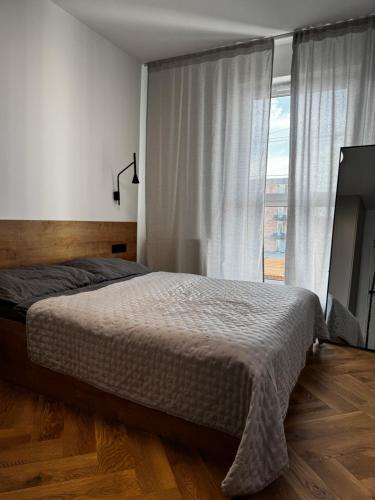 a bedroom with a bed and a large window at Japandi Apartment Pogórze in Pogórze