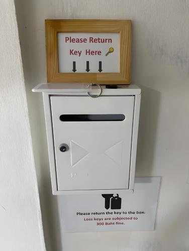 a wooden box on top of a white mailbox at GO INN Siriraj BKK โกอินน์ ศิริราช in Bangkok Noi