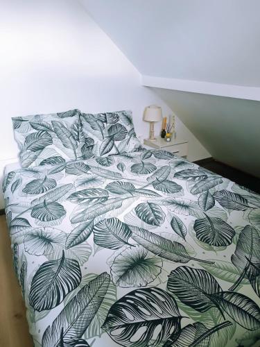 - une chambre avec un lit et une couette verte et blanche dans l'établissement Still vintage 67 appartement proche de Strasbourg, à Still