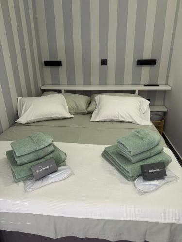 - un lit avec 3 serviettes vertes dans l'établissement Studio apartman Mango, à Jadranovo