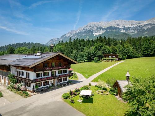 an aerial view of a house with mountains in the background at Oberachenhof in Ellmau