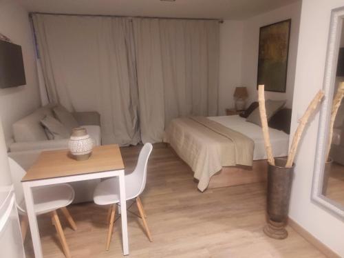 a bedroom with a bed and a desk and a table at HOTEL apartamentos SEVEN ROOMS in Punta Umbría