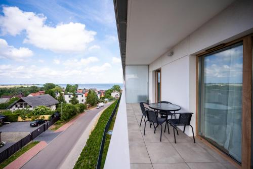 a balcony with a table and chairs and a view of a street at ReVital Mechelinki by Homeprime Parking Free in Mechelinki