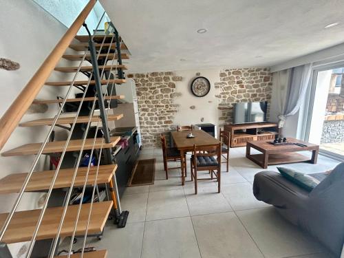 a living room with a staircase and a dining room at Logement thérapie bien-être in Pont-lʼAbbé
