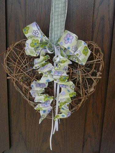 a heart shaped wreath with a bow on a door at Denninger's Ferienhäusle in Riezlern
