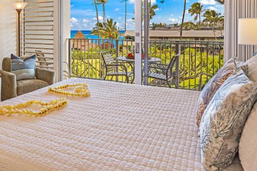 a bed on a balcony with a view of the ocean at Napili Shores G258 Studio Condo condo in Kahana