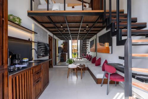 een keuken en een woonkamer met rode stoelen en een bank bij Palermo Suites by Betterplace in Ubud