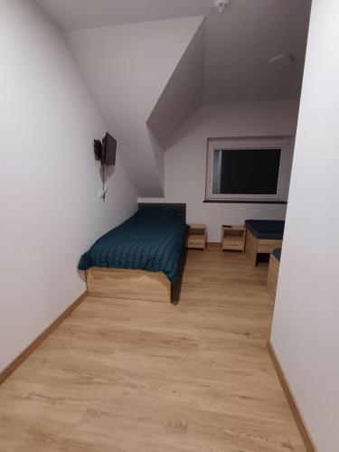 a bedroom with a bed and a flat screen tv at Noclegi u Wilka in Chorzelów
