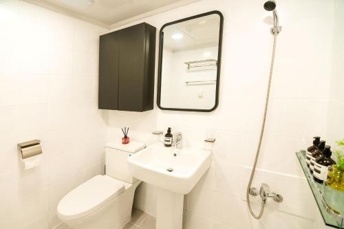 a bathroom with a sink and a toilet and a mirror at Ongi House in Seoul