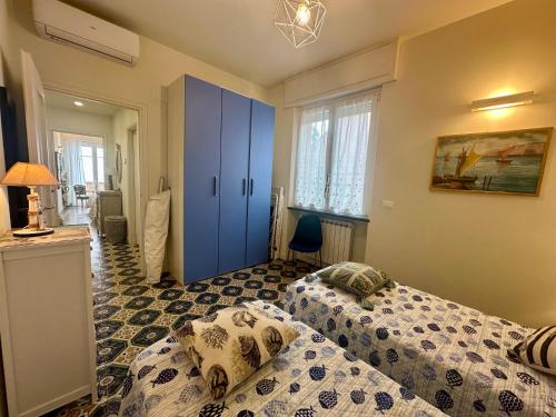 a bedroom with two beds and a blue cabinet at Villa Liliana - Casa Aurora - Trilocale Elegante con Balcone Vista Mare - Accesso Diretto alla Spiaggia in Varigotti