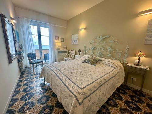 a bedroom with a large bed and a window at Villa Liliana - Casa Aurora - Trilocale Elegante con Balcone Vista Mare - Accesso Diretto alla Spiaggia in Varigotti