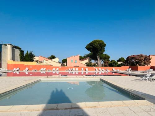 a swimming pool with chairs and a blue sky at Maisonnette les oliviers in Argelès-sur-Mer