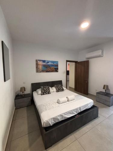 ein Schlafzimmer mit einem großen Bett und zwei Nachttischen in der Unterkunft Central and Cozy Room in Msida