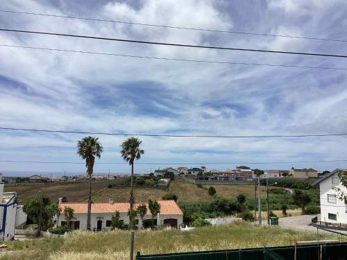 a town with palm trees and houses on a hill at VISTA MAR in Lourinhã
