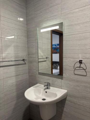 ein weißes Badezimmer mit Waschbecken und Spiegel in der Unterkunft Central and Cozy Room in Msida